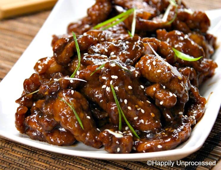 mongolian beef on a white plate with sesame seeds