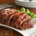 sliced meatloaf with honey whiskey bbq glaze on white plate