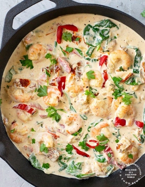 Tuscan Garlic Shrimp with Sundried Tomatoes and Spinach in a creamy garlic parmesan sauce in cast iron skillet