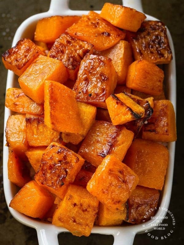 white casserole dish with roasted caramelized butternut squash