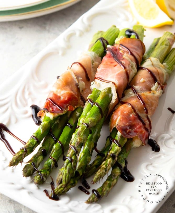 PROSCIUTTO WRAPPED ASPARAGUS - Garlic and Herb cheese is spread over prosciutto and then wrapped around fresh asparagus and baked until tender #asparagus #prosciutto #appetizer #happilyunprocessed