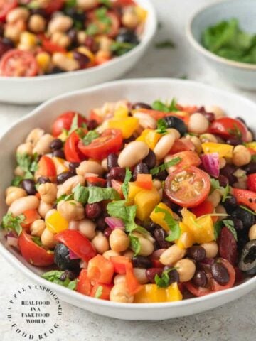 VIBRANT SUMMER 4 BEAN SALAD - 4 types of beans, colorful peppers, tomatoes, olives and red onion in a emulsified oil and vinegar dressing #summerrecipes #beansalad #potluck #healthy #summer #salads #happilyunprocessed