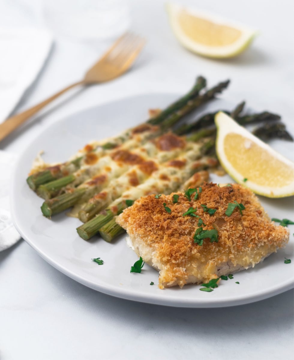 Baked Cod with a Panko breadcrumb topping drizzled in butter with a side of cheese asparagus