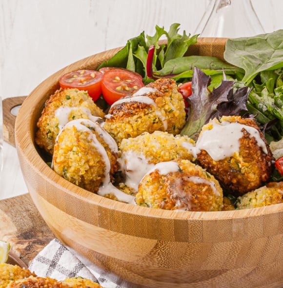 Delicious homemade falafels over green salad in falafel bowl