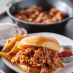 sloppy joe sandwich piled high on a toast bun with ground beef pepper and onions in a tomato sauce