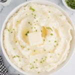 Garlic Mashed Potatoes with Chives Garlic mashed potatoes with chives and butter in a bowl.