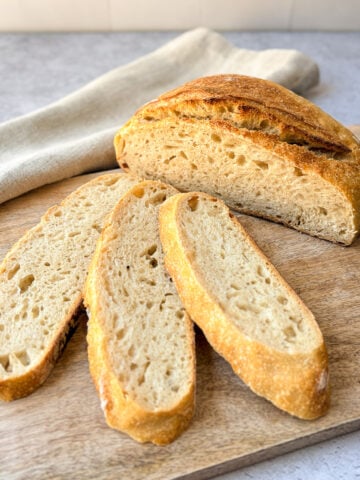 Sourdough bread loaf and slices on a cutting board